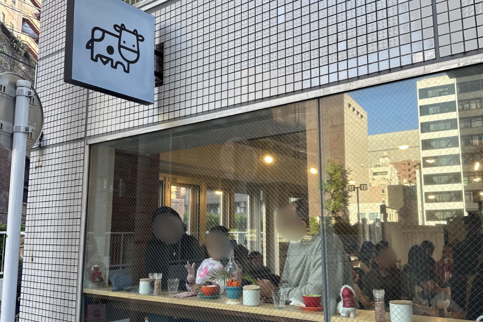 Brown Cow Cafeの牛のロゴ看板と大きな窓
