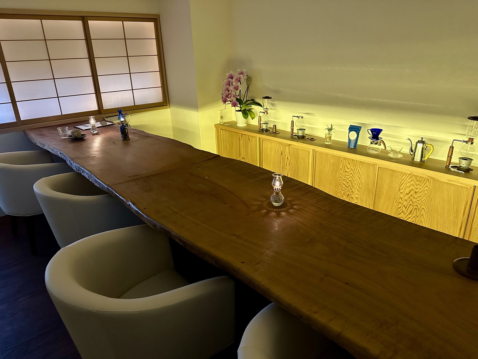 一枚板のカウンターと白い椅子が並ぶ瑠璃色コーヒーの店内